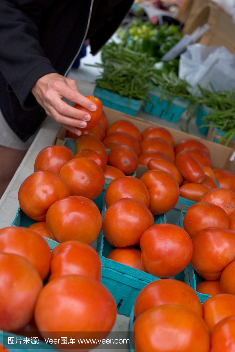从农贸市场挑选番茄的妇女。